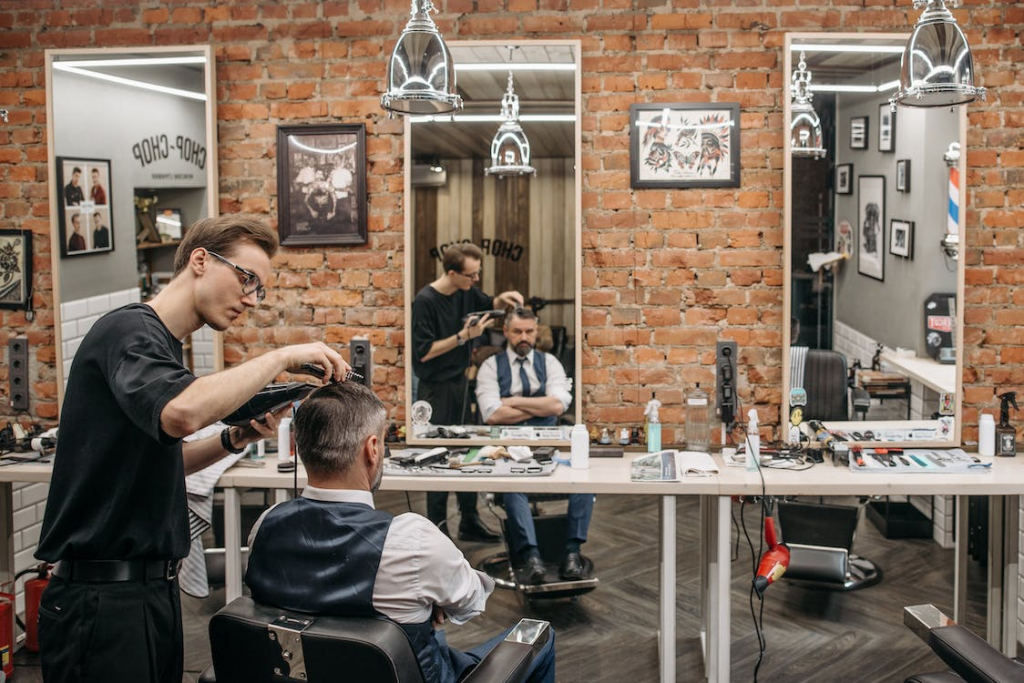 Esterilização em Barbearias: Entenda Como Garantir Segurança e Higiene aos Clientes - barbeiro cortando um cabelo